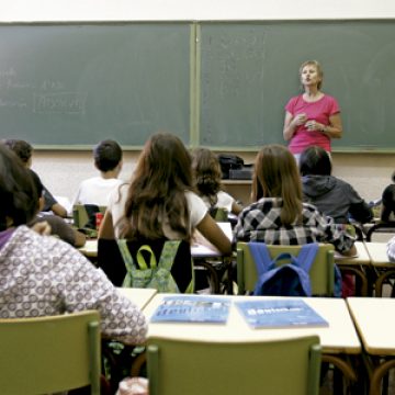 profesora en el aula en un colegio dando clase a alumnos estudiantes