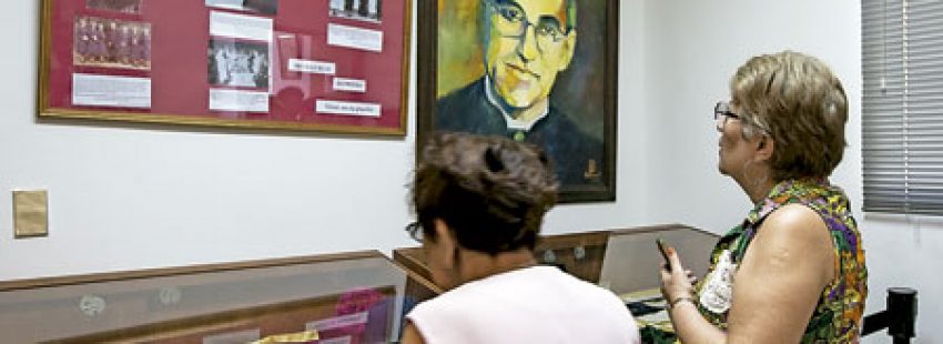 dos señoras rezan y visitan una exposición sobre beato Óscar Romero