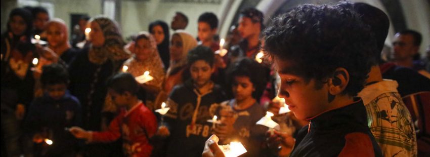 jóvenes niños y adultos en Egipto rezan por las víctimas del ataque terrorista contra una iglesia cristiana en abril