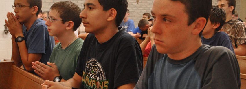 niños en una capilla rezando por las vocaciones