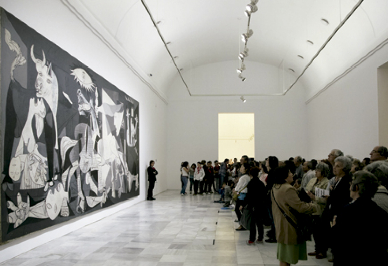grupo de gente visitantes observan el Guernica cuadro de Picasso en el Museo Reina Sofía