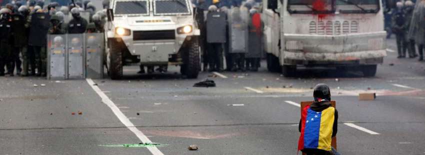 Un joven se enfrenta a los carros de la policía en Caracas