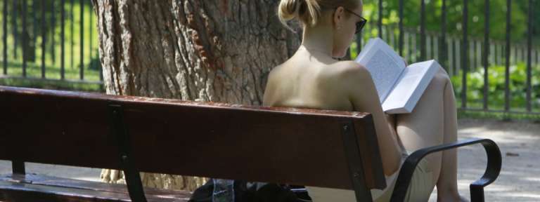 Mujer, en un banco de un parque leyendo /EFE