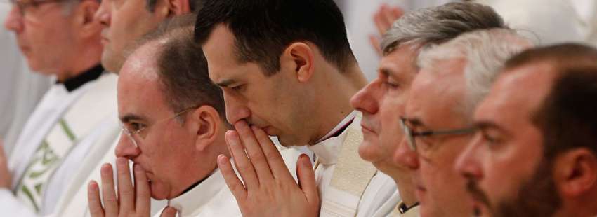 grupo de sacerdotes en una celebración misa rezando en silencio