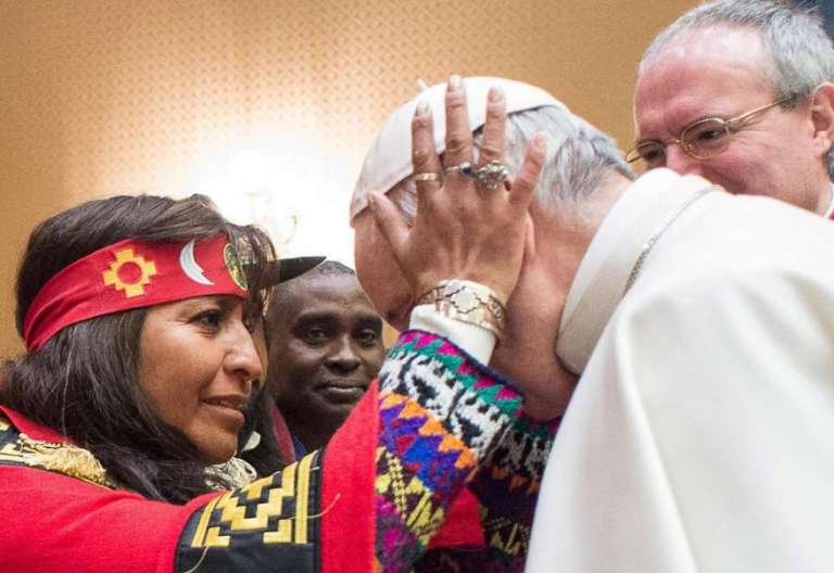 Una mujer indígena bendice al Papa Francisco/CNS