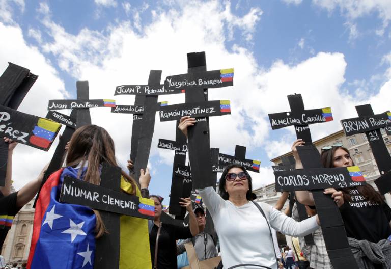 peregrinos de Venezuela en el Vaticano con cruces con nombres de víctimas de la crisis