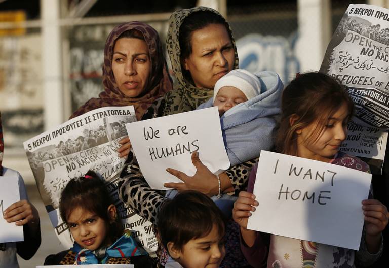 madres y niños refugiados en Grecia protesta con carteles Somos humanos demandan mejores condiciones de vida campo refugiados