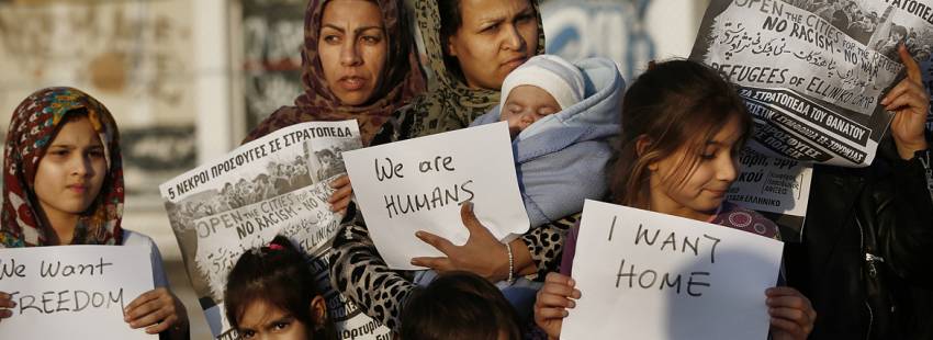 madres y niños refugiados en Grecia protesta con carteles Somos humanos demandan mejores condiciones de vida campo refugiados