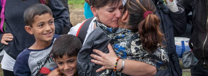 Una voluntaria a un grupo de refugiados en Grecia/CNS