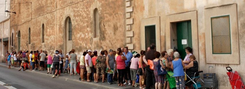 Un grupo de personas esperan para recibir alimentos Cáritas archivo