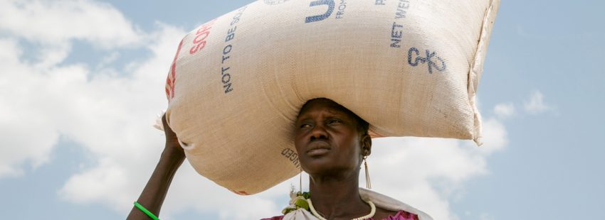 mujer en Sudán del Sur con un saco de comida ayuda humanitaria