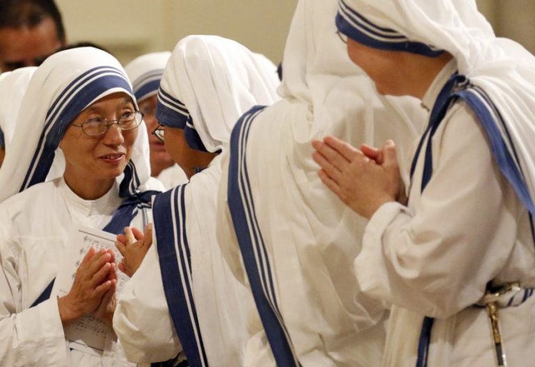 Sister Rose Clare Lee, left, regional superior of the Missionaries of Charity, joins other nuns in exchanging the sign of peace during a Mass of thanksgiving for the canonization of St. Teresa of Kolkata at St. Patrick's Cathedral in New York City Sept. 10. The liturgy was celebrated by Cardinal Timothy M. Dolan of New York. (CNS photo/Gregory A. Shemitz)