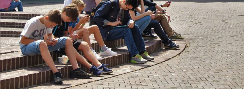 grupo de jóvenes adolescentes en la calle estudiando sentados