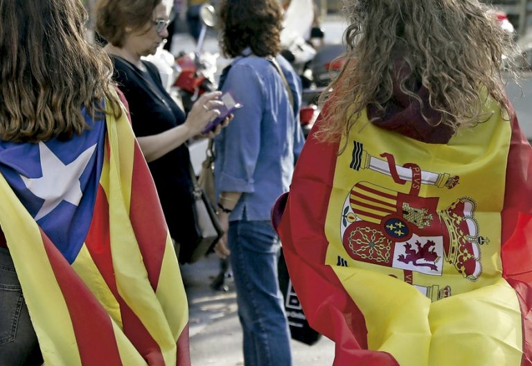 dos chicas con la bandera estelada independentistas de Cataluña y la bandera de España 1 octubre 2017