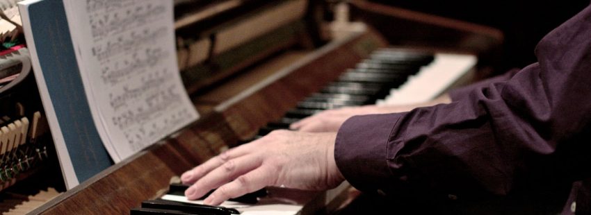 pianista manos de un músico tocando el piano con partitura