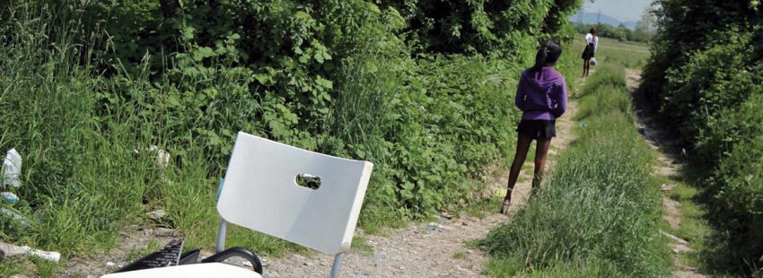 dos chicas jóvenes mujeres prostitulas en una selva o campo con una silla y un paraguas