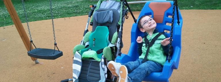 niño con discapacidad jugando en un columpio