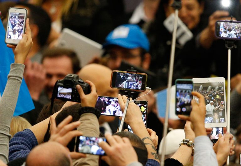 gente en una audiencia grabando con sus teléfonos al papa Francisco