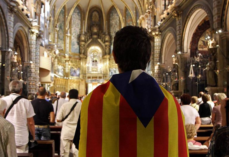 joven con una bandera estelada independentista Cataluña en una iglesia