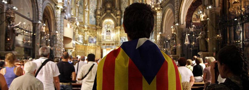 joven con una bandera estelada independentista Cataluña en una iglesia