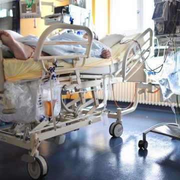 Un enfermo en una camilla en una habitación llena de aparatos médicos