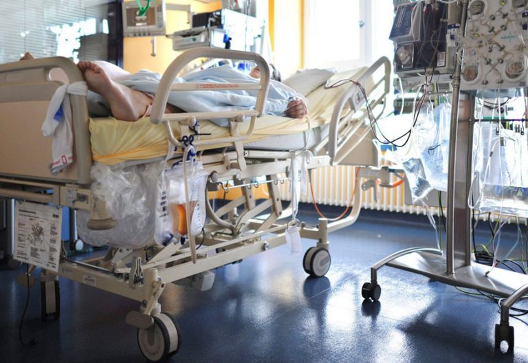 Un enfermo en una camilla en una habitación llena de aparatos médicos