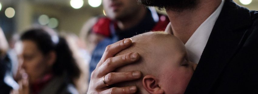 Un padre con su hijo bebé participan en una eucaristía en Cracovia/JMJ