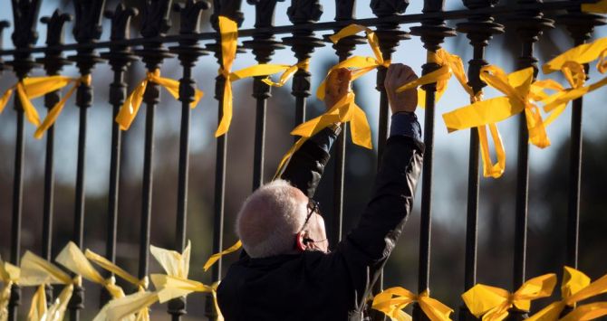Un hombre coloca lazos amarillos para exigir la libertad de los presos del procés