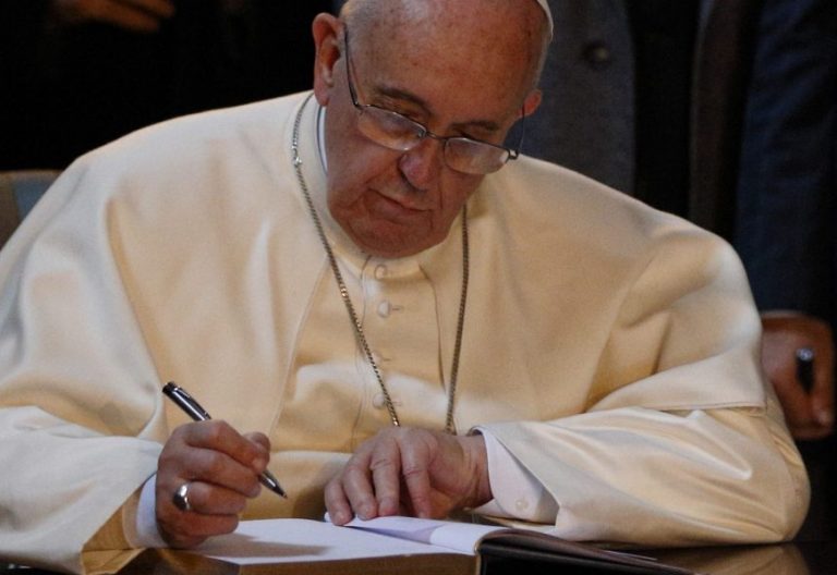 El Papa Francisco firma en un libro