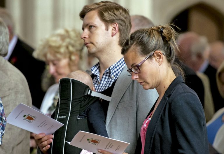 Pareja en misa siguiendo las lecturas