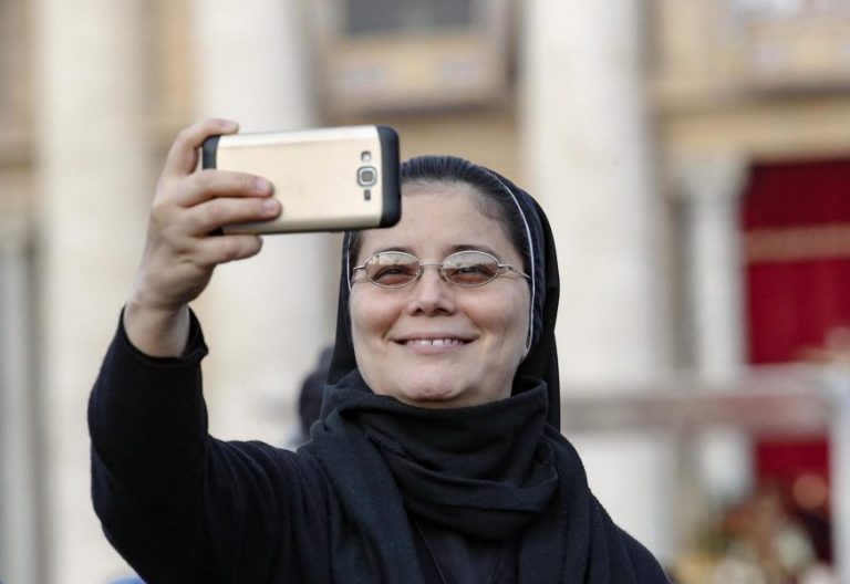 Una religiosa con un móvil, en la canonización de Oscar Romero/EFE