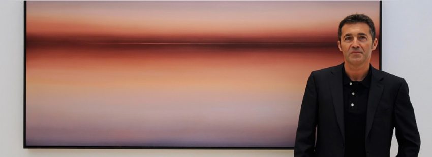 jose saborit con una de las obras de su exposición mientras la luz