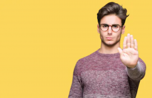 Young Handsome Man Wearing Glasses Over Isolated Background Doing Stop Sing With Palm Of The Hand.