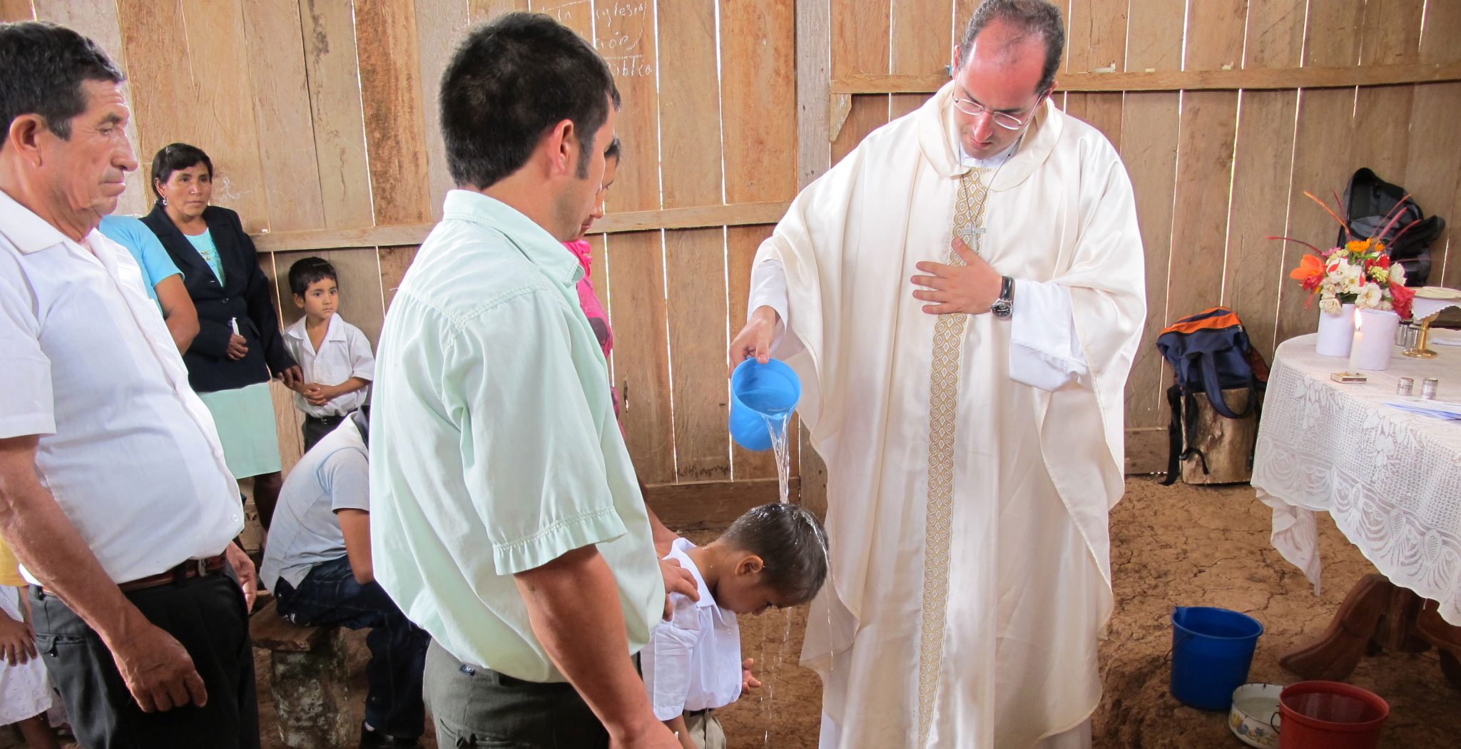 Misionero bautizando a un niño en Perú