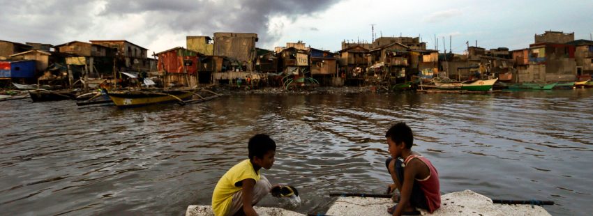 Dos niños flotan sobre aguas contaminadas en los suburbios de Filipinas