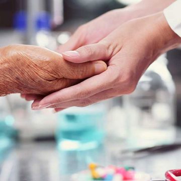 La mano de una enfermera toma la de un enfermo de Cuidados paliativos