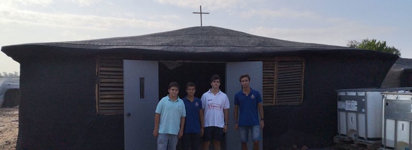 cofrades ante una capilla en construcción en un asentamiento chabolista de inmigrante en Lucena,