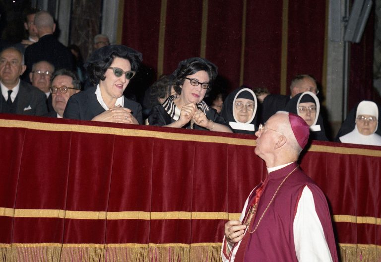 Un padre conciliar pasa ante las tribuna donde se sienta las mujeres en el Vaticano II