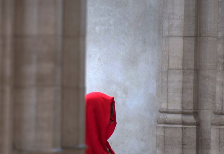fotos simbolica de una persona entre columnas vaticanas o muro de iglesia