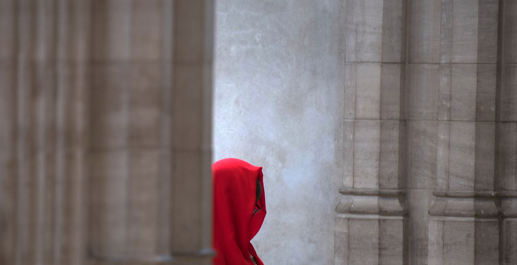 fotos simbolica de una persona entre columnas vaticanas o muro de iglesia