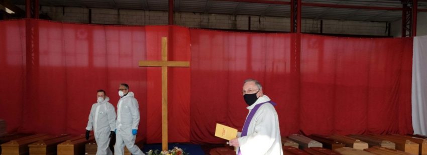 Ponte San Pietro (Italy), 03/04/2020.- A priest wearing a protective face mask blesses the coffins