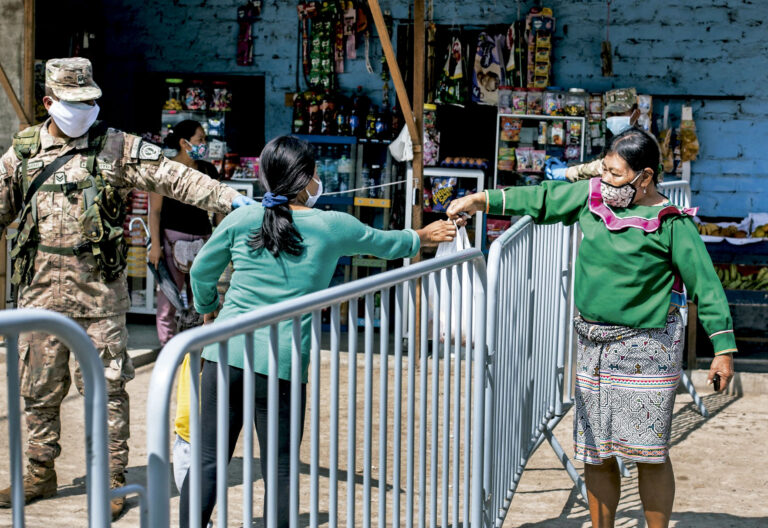 Una indígena pasa alimentos a una mujer en Cantagallo. Lima (Perú).