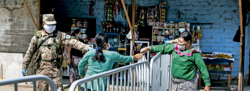 Una indígena pasa alimentos a una mujer en Cantagallo. Lima (Perú).