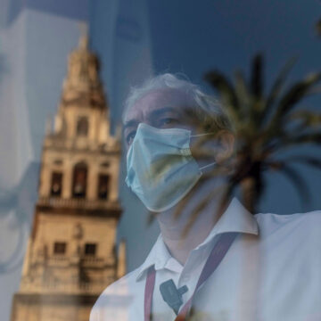 mascarilla tras cristal, iglesia al fondo
