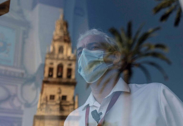 mascarilla tras cristal, iglesia al fondo
