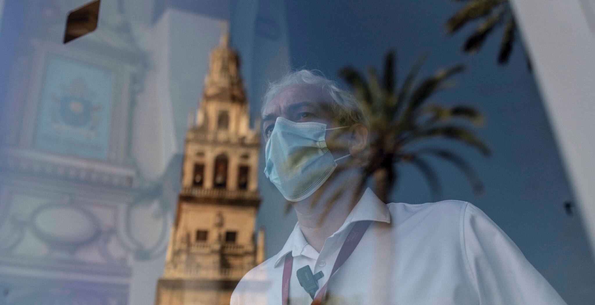 mascarilla tras cristal, iglesia al fondo