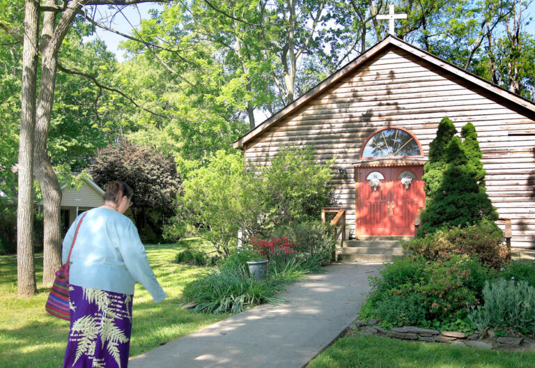Mujer dirigiéndose a una capilla en el campo