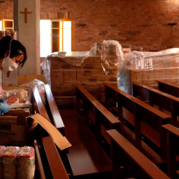 Una voluntaria organiza un lote de alimentos en la parroquia de Nuestra Señora de Bellvitge que la