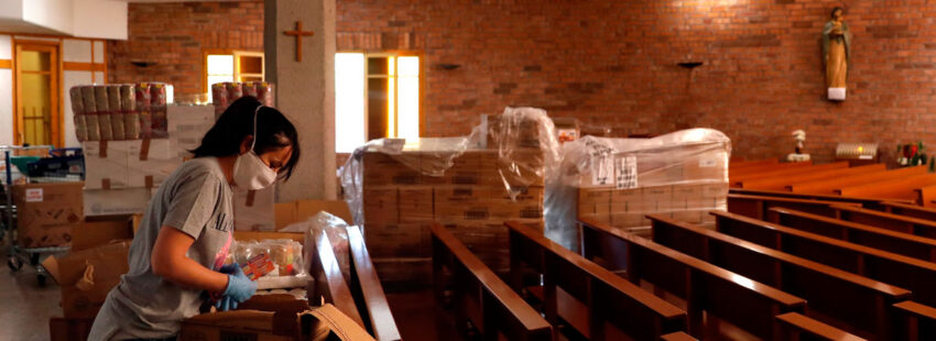 Una voluntaria organiza un lote de alimentos en la parroquia de Nuestra Señora de Bellvitge que la FundaciÛn La Vinya de L'Hospitalet de Llobregat