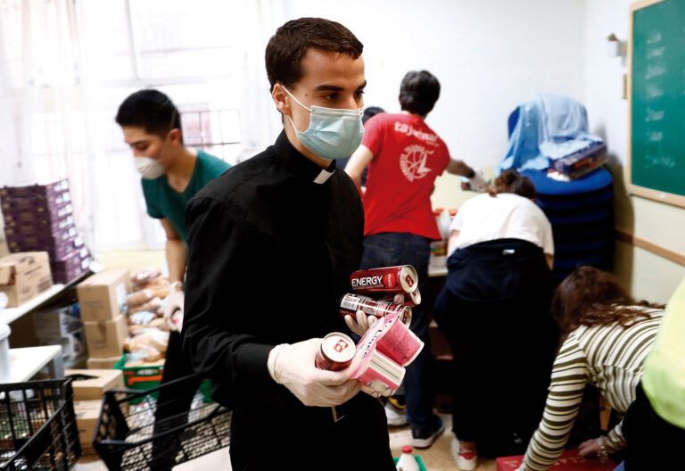 sacerdote, entrega alimentos en parroquia